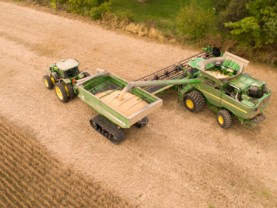 farm industry farmers using farm equipment to extract soil beans from field